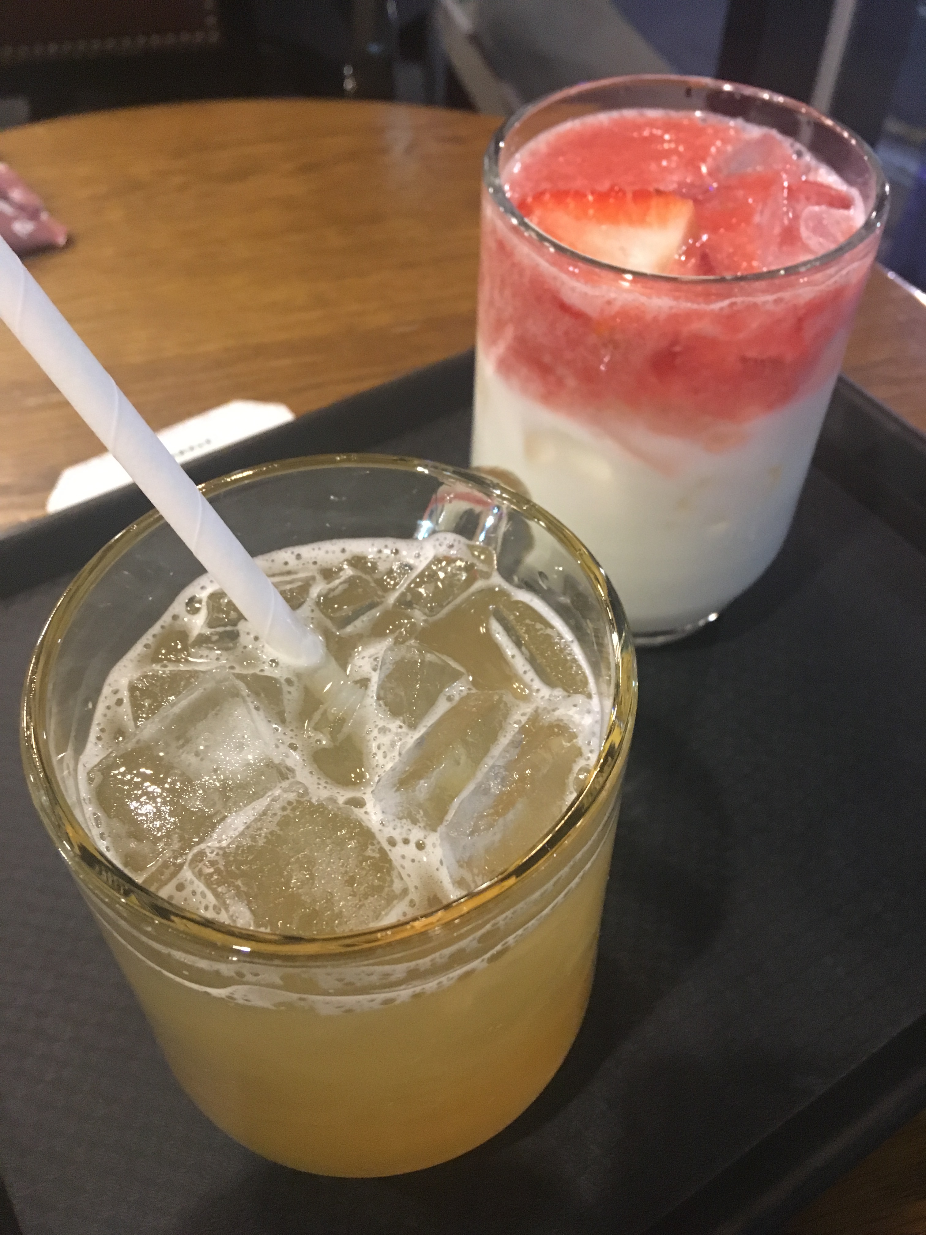 Green Tea Limonade and Strawberry Latte drunk inside on a reusable cups with a paper straws.